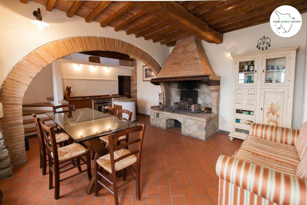 una cucina e una sala da pranzo con camino in pietra di Casa Coccinelle a Mazzolla