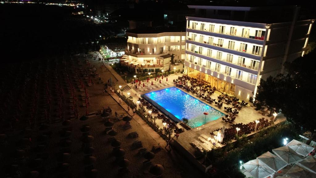 un hotel con piscina frente a un edificio en Hotel Elesio, en Golem