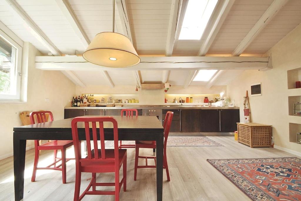 una sala da pranzo con tavolo e sedie rosse di Design loft ski in ski out a La Thuile