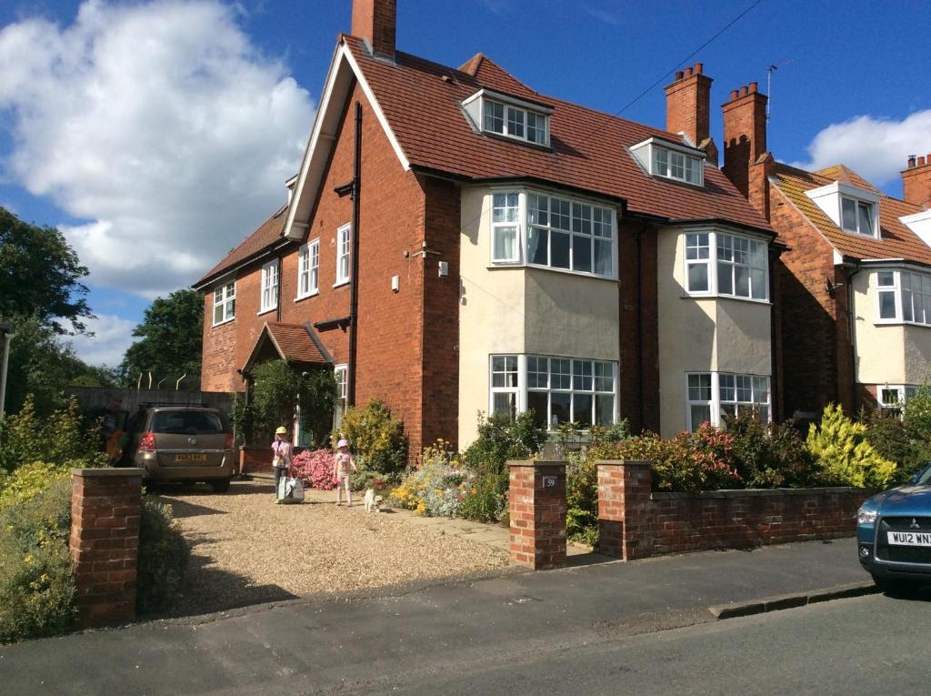 a house with a child standing in front of it at Merlstead House in Hornsea