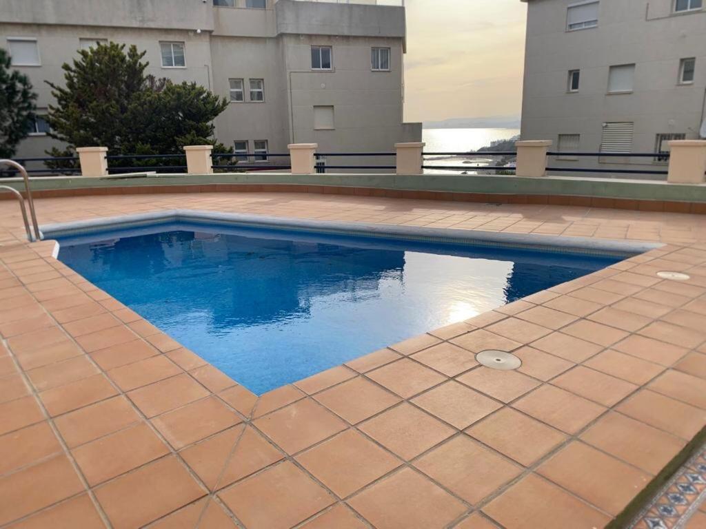 a swimming pool with blue water on a patio at apartamento torrequebrada in Benalmádena