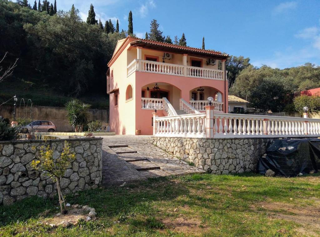 Casa grande con pared de piedra y balcón. en Villa Silvia, en Ágios Matthaíos