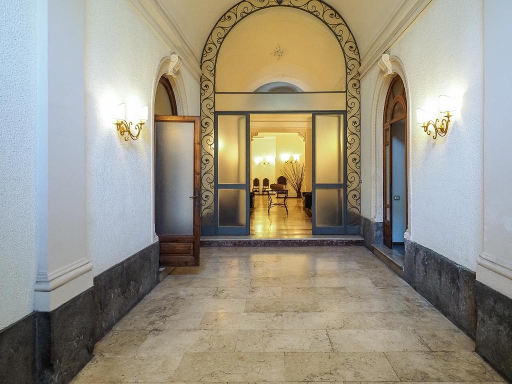pusty korytarz z łukiem w budynku w obiekcie Appartamenti Villa Bellini w Katanii