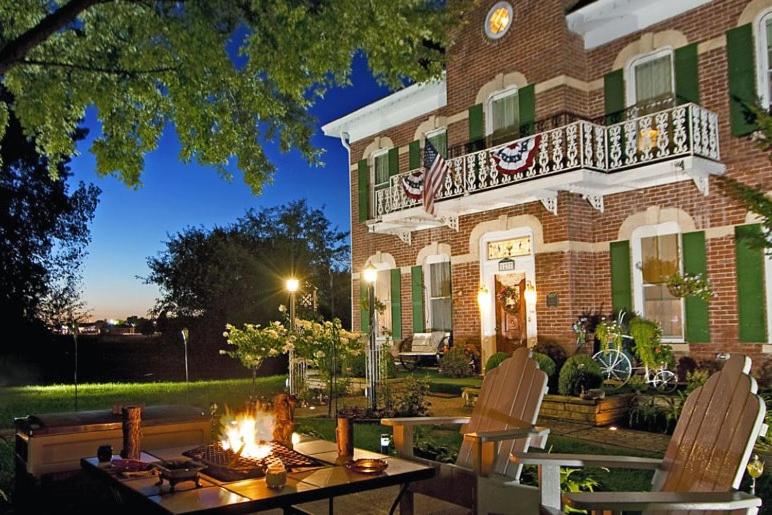 a restaurant with tables and chairs and a fire place at Cloran Mansion Bed & Breakfast in Galena