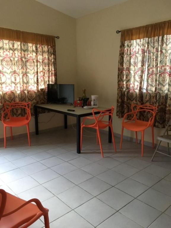 um quarto com uma mesa, cadeiras e cortinas em Casa de Campo Rio Arriba em Arecibo