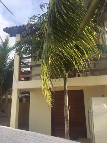 a palm tree in front of a building at Chalé encontro das aguas in Barra do Cunhau