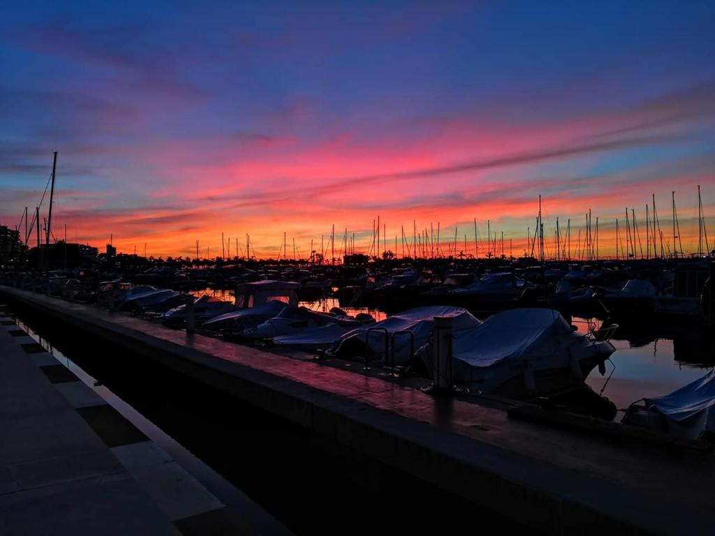 a group of boats parked in a marina at sunset at Apartamento Caravaca in Santa Pola