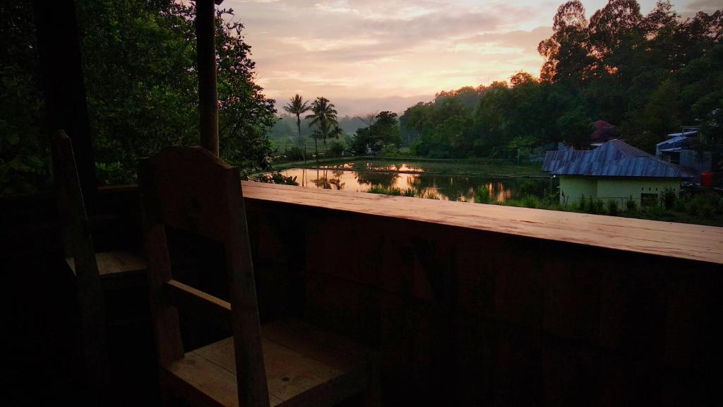 - une vue sur la rivière depuis une balustrade en bois dans l'établissement Mama Tia Family Homestay, à Rantepao