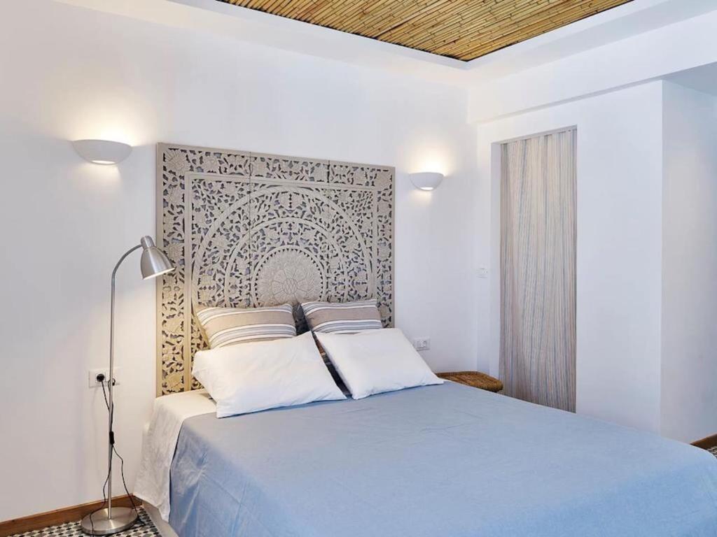 1 dormitorio con cama azul y pared en KALITHEA-HILLS APARTMENT 3, en Koskinou