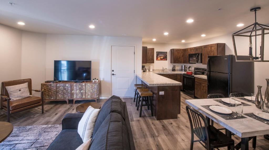 a living room and kitchen with a couch and a table at Moab Redcliff Condos in Moab
