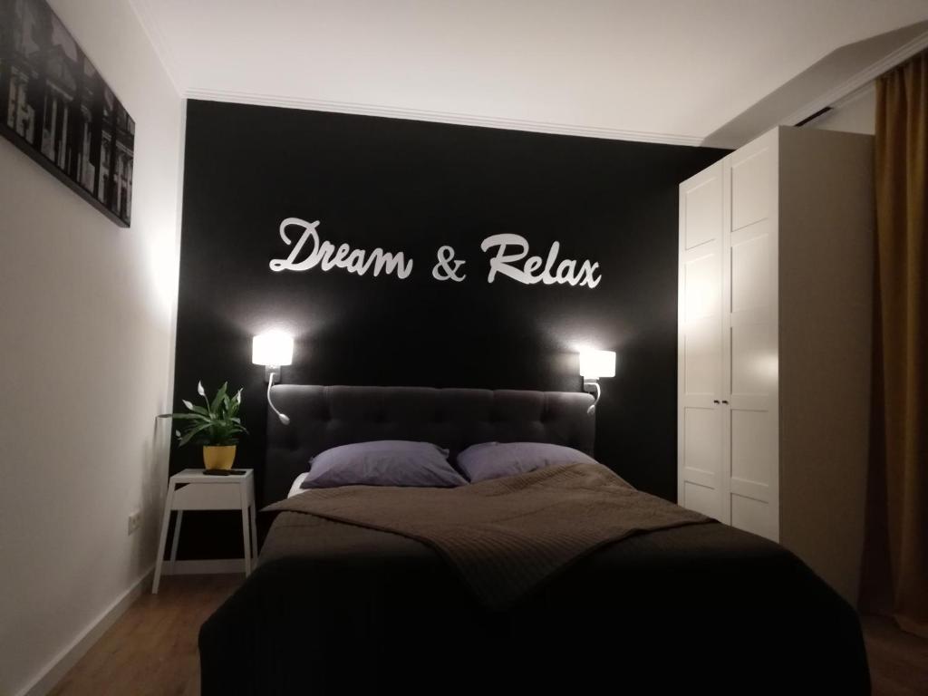 ein Schlafzimmer mit einem Bett mit einem Schild an der Wand in der Unterkunft Dream & Relax Apartment's Messe in Nürnberg