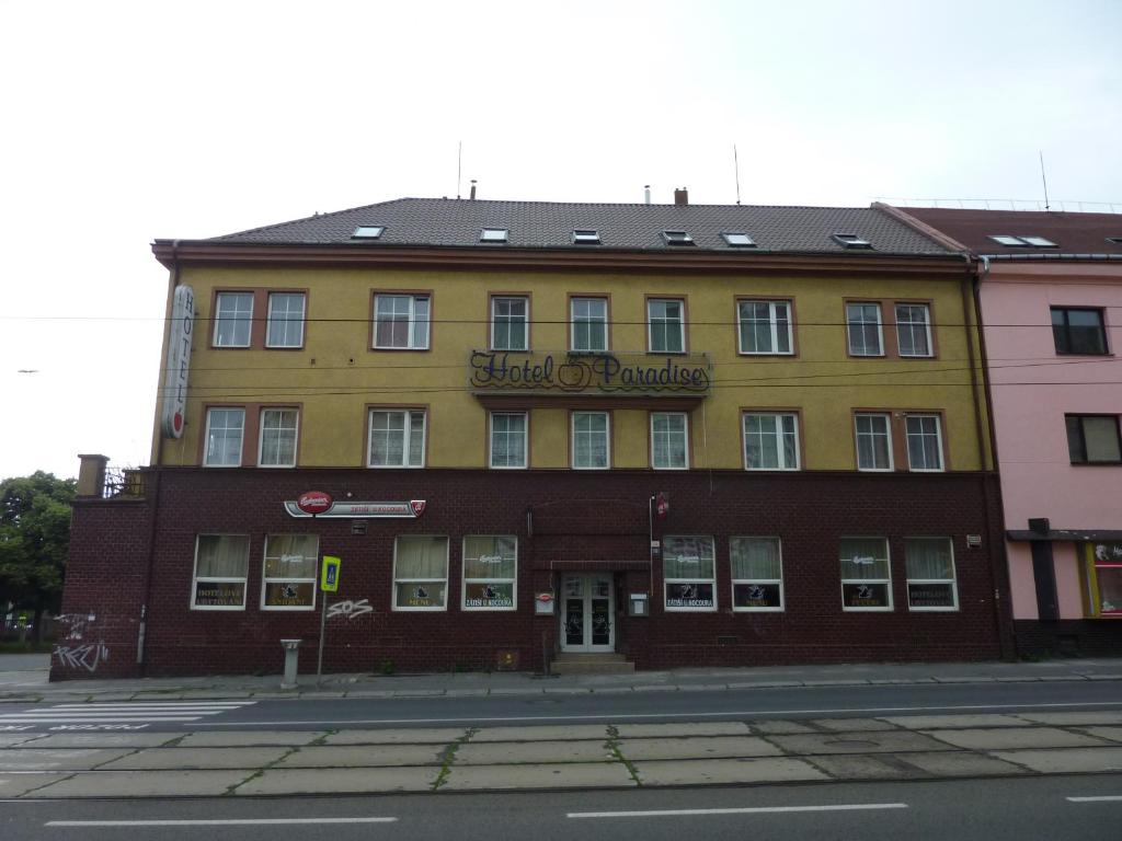 a yellow and brown building on the corner of a street at Hotel Paradise in Ostrava