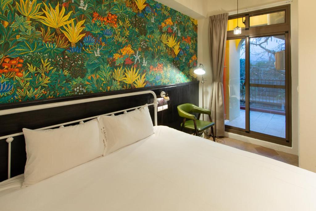 a bedroom with a large bed with a painting on the wall at Love Inn in Hualien City