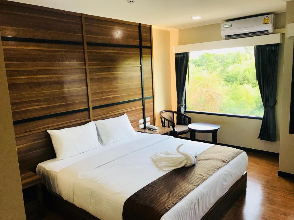 a bedroom with a large bed and a large window at ATK Garden Hills in Hat Yai
