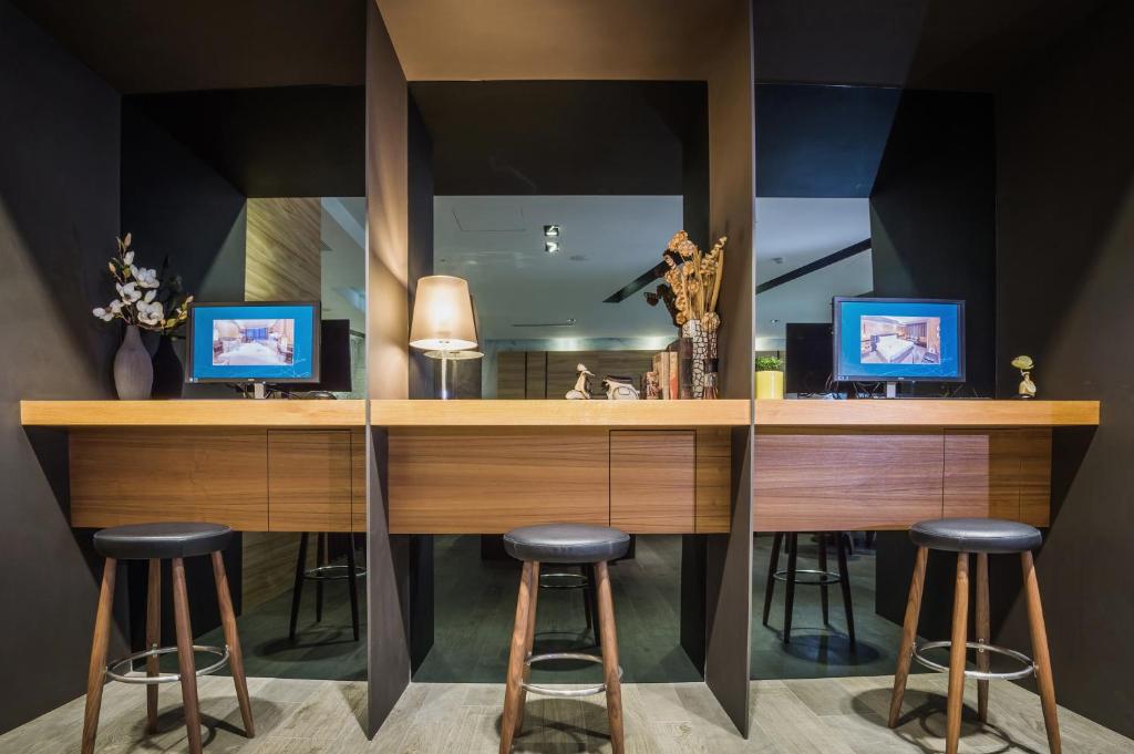 a room with a desk with stools and a mirror at La Vida Hotel in Taichung