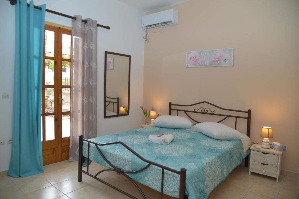 a bedroom with a bed with a blue comforter at River house fully renovated & equipped 10' from DT in Potamós