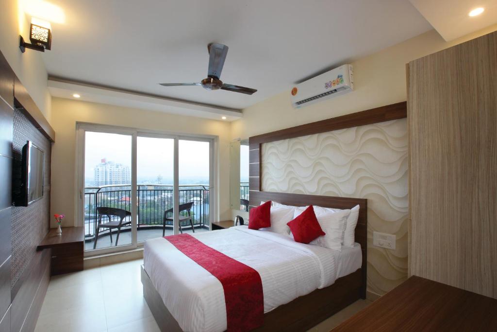 a hotel room with a bed and a balcony at Laimar Suites in Cochin