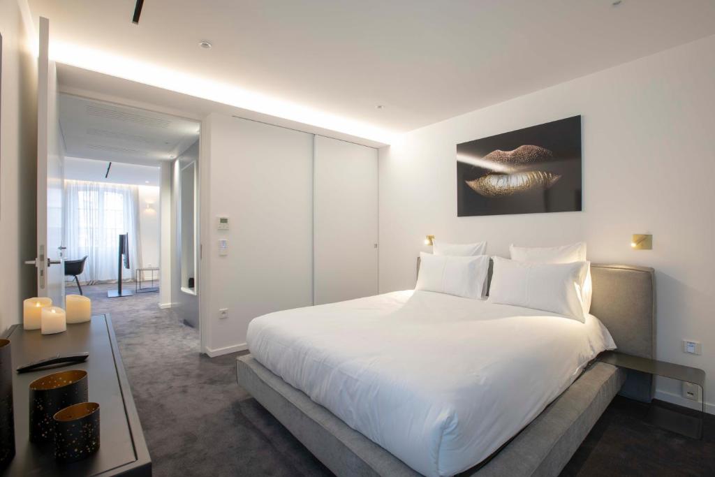 1 dormitorio blanco con 1 cama blanca grande con almohadas blancas en BORD EAU Guest House en Colmar