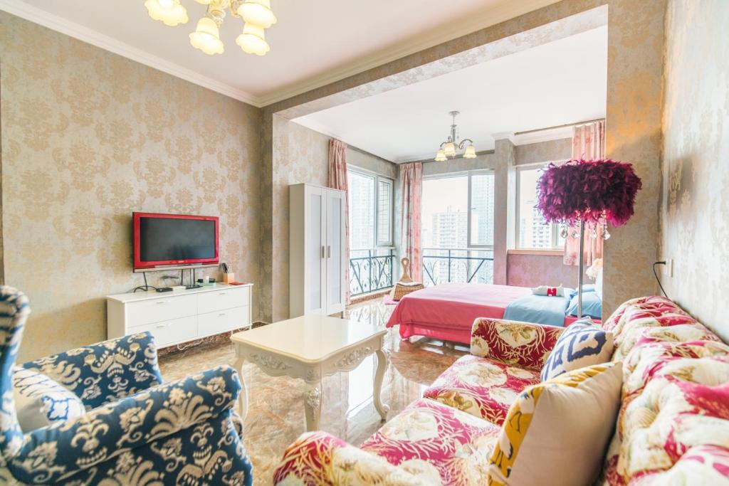 a living room with a couch and a tv and a bed at Xiao Yu B&B Apartment Near Jiefangbei and Hongyadong in Chongqing