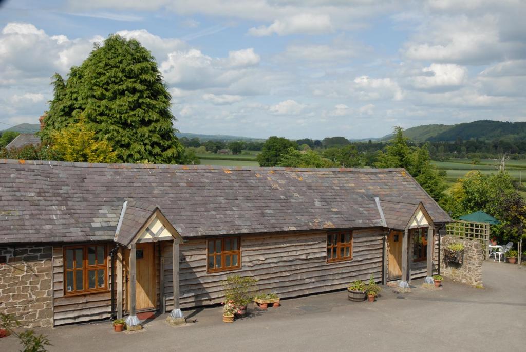 a small wooden cabin with a tree in the background at Highgrove Barns in Craven Arms