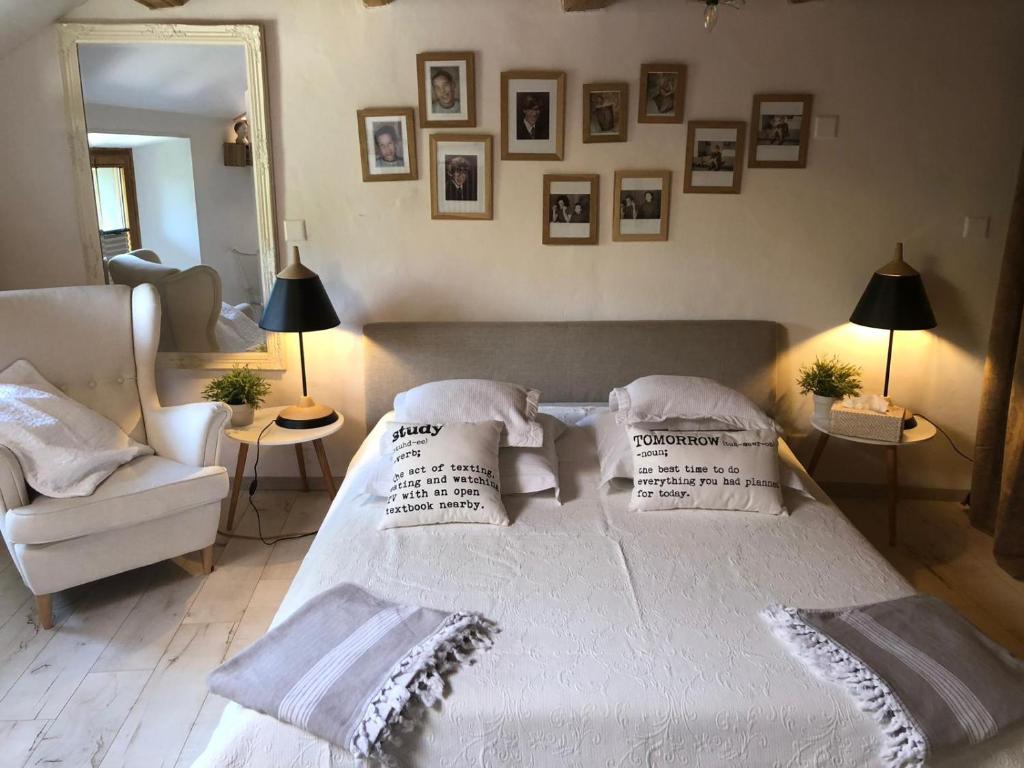 una camera da letto con un letto bianco e cuscini sopra di LaMaisonRouge chambre d'hôtes a Cormondreche