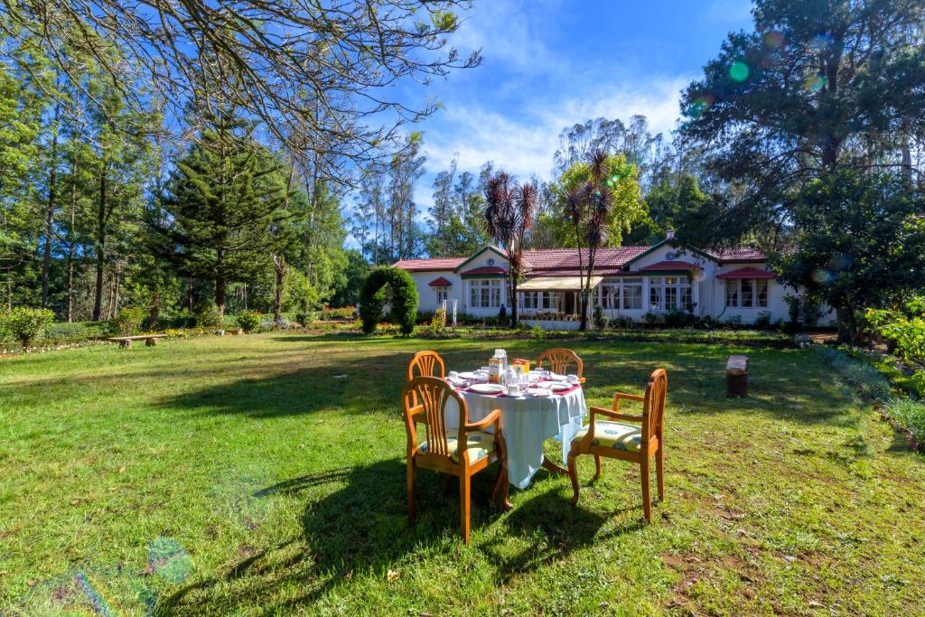 einen Tisch im Hof eines Hauses in der Unterkunft SaffronStays Milton Abbott Estate, Ooty in Udagamandalam