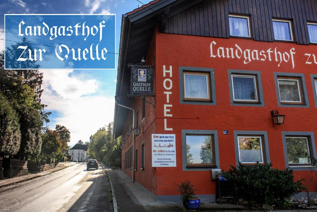 a red building on the side of a street at Landgasthof zur Quelle in Seeshaupt