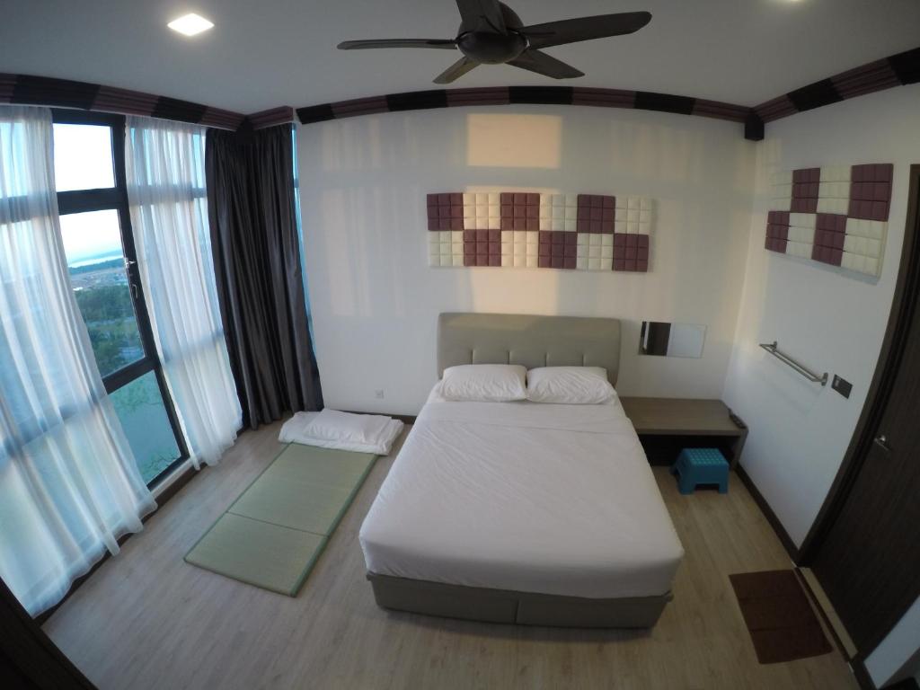 Green Haven Homestay في باسير غونداغ: غرفة نوم بسرير ومروحة سقف