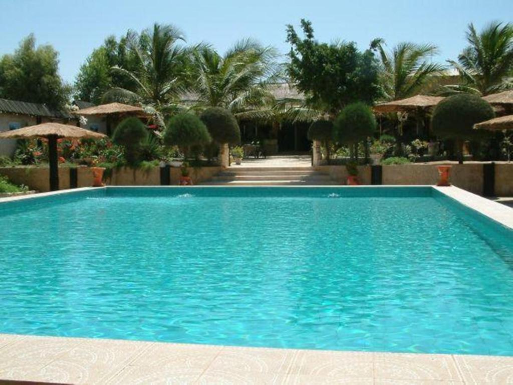 une grande piscine bleue dans un complexe dans l'établissement Hotel Club Safari, à Mbour