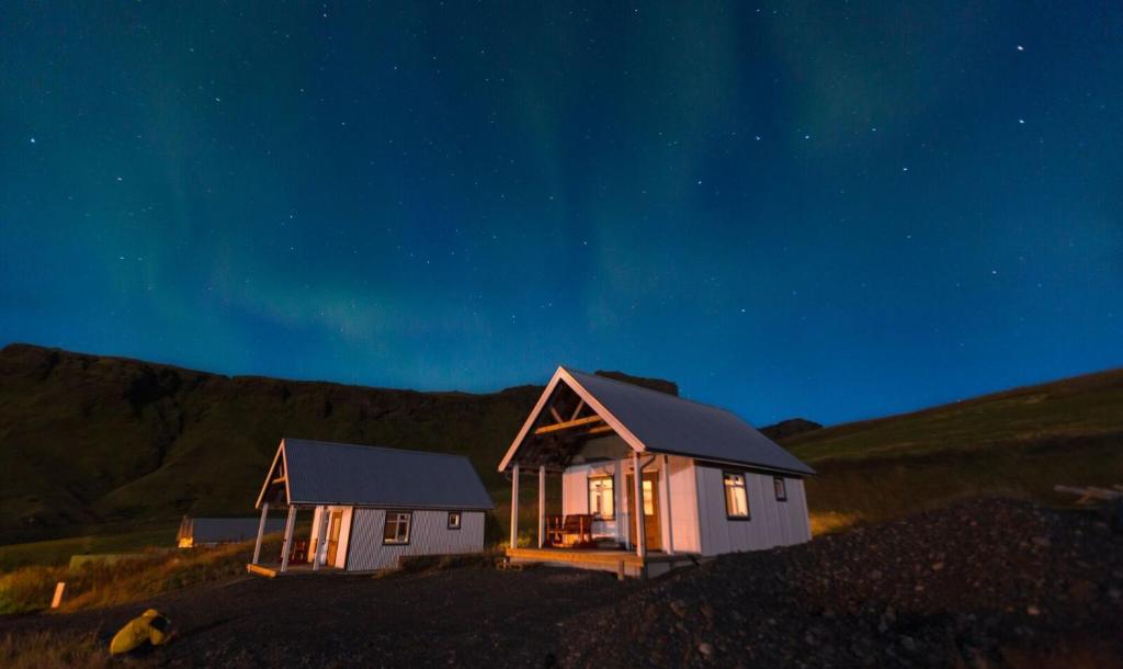 a small house sitting on top of a hill at night at Norður-Vík in Vík