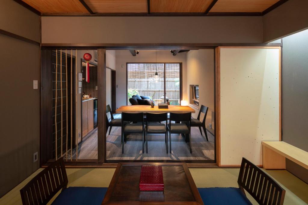 a dining room and living room with a table and chairs at Ainotsuji Machiya House in Kanazawa
