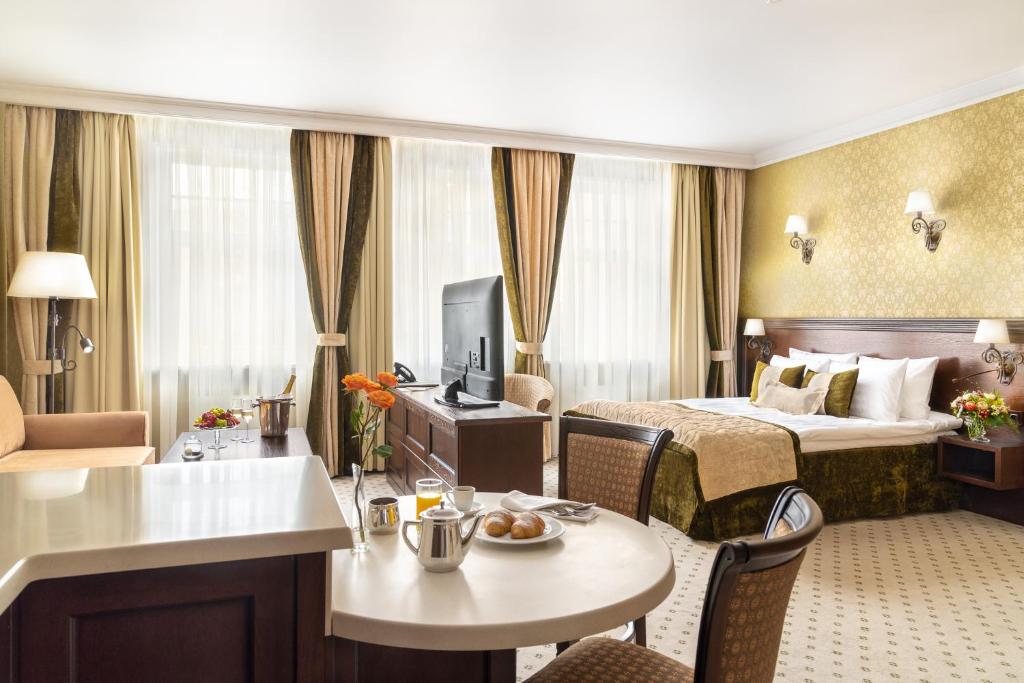 een hotelkamer met een bed en een woonkamer bij Garden Street Hotel in Sint-Petersburg