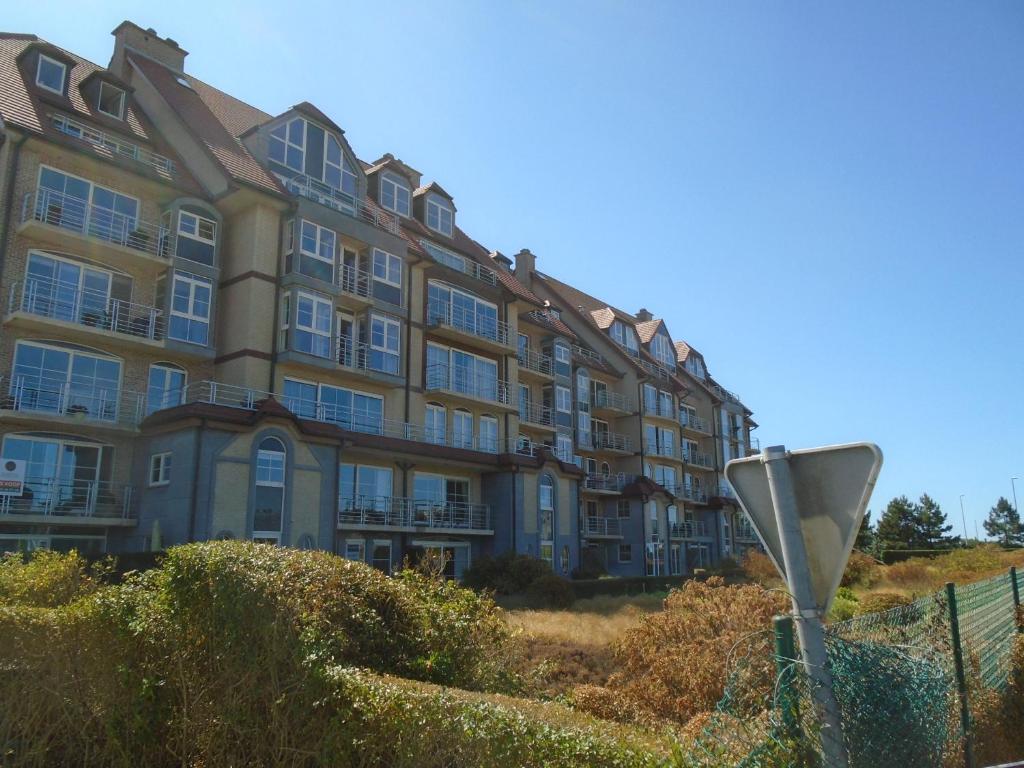 a large apartment building on a hill next to a fence at BLANKENBERGE FLAT in Blankenberge