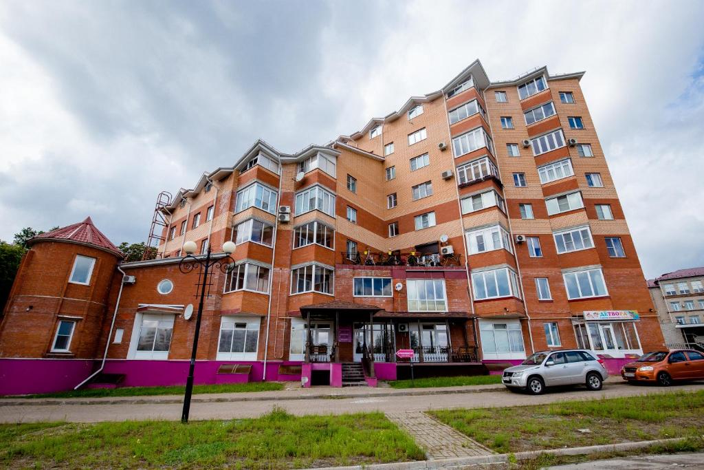 庫爾斯克的住宿－格斯特沃大教堂斯特羅加諾維克公寓式酒店，前面有停车位的建筑
