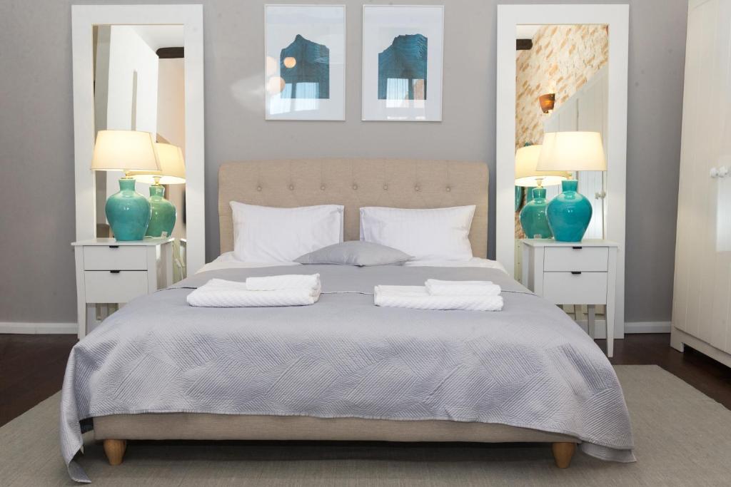 um quarto com uma cama com dois espelhos e vasos azuis em Cluj Lux Apartment Unirii em Cluj-Napoca