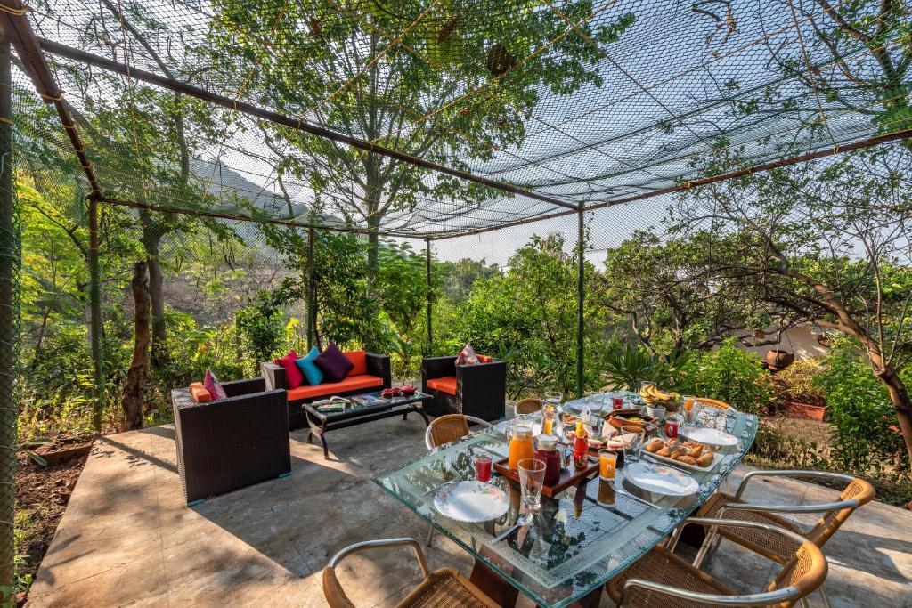 a table and chairs on a patio with a view at SaffronStays Masaya, Alibaug - pet-friendly villa with alfresco dining in Alibaug