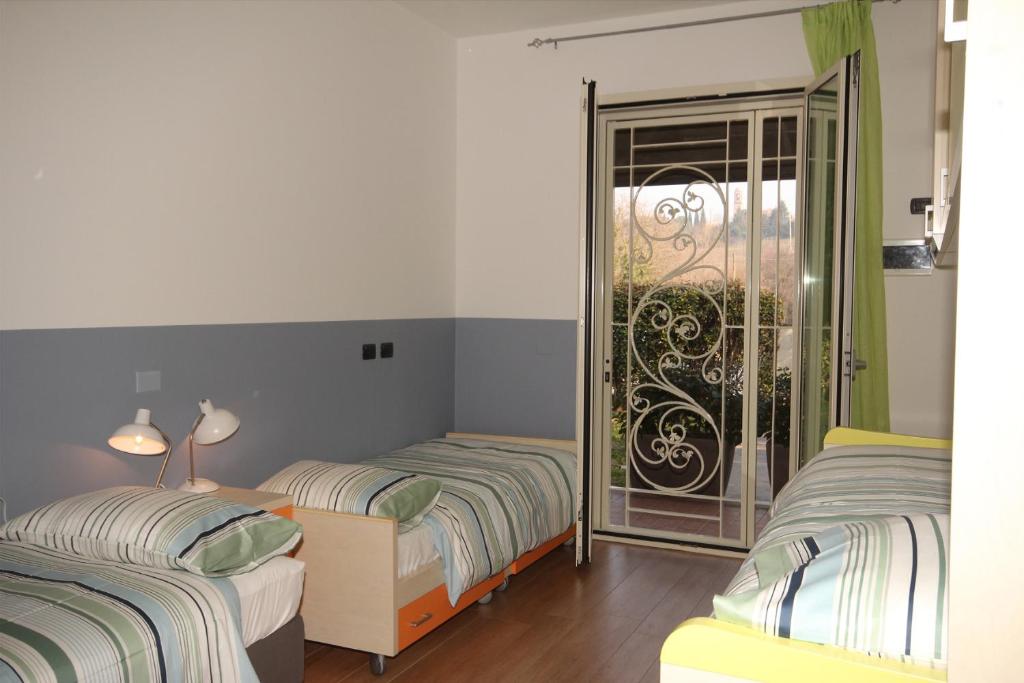 a bedroom with two beds and a balcony at Magnolia in Savignano sul Rubicone