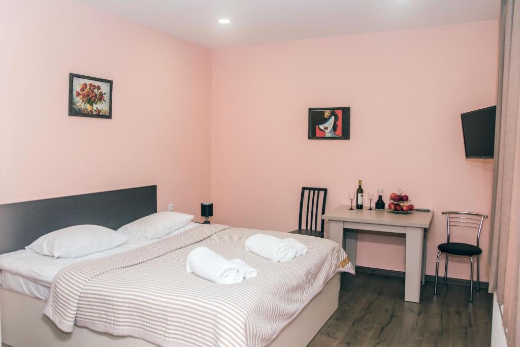 1 dormitorio con cama, escritorio y mesa en Red Hotel en Tiflis