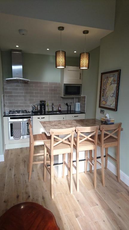 a kitchen with a table and two chairs and a counter at Murrayfield Spacious 1 bedroom apartment in Edinburgh