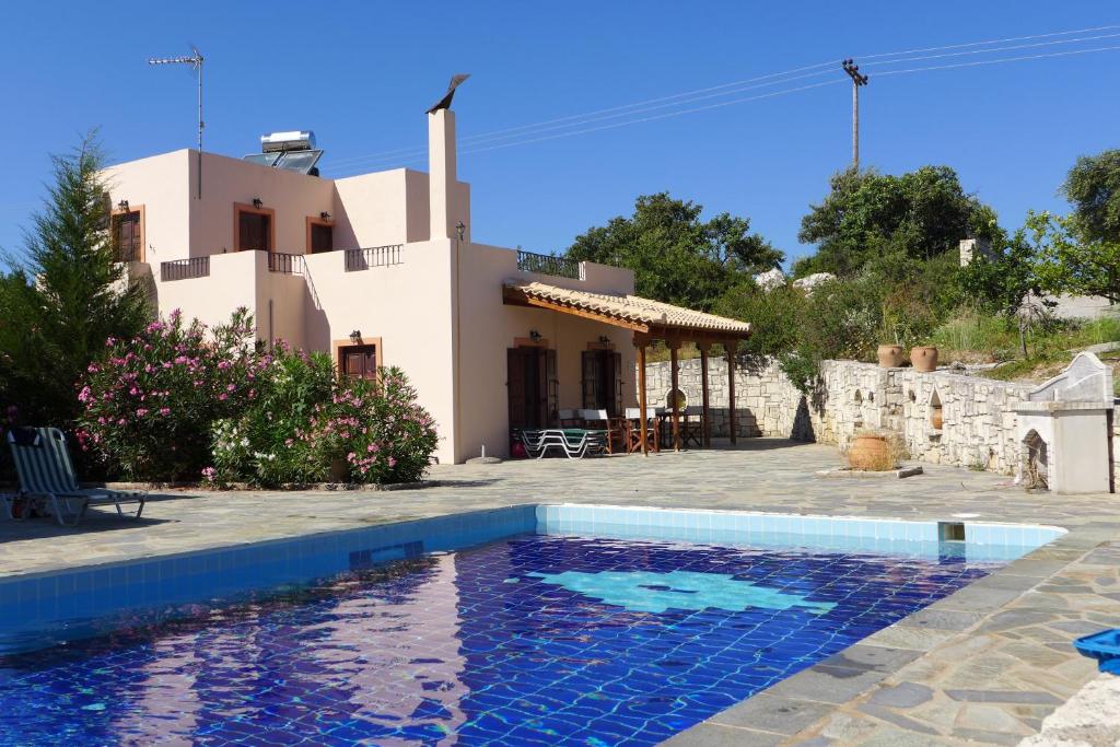 a villa with a swimming pool in front of a house at Oros Villas in Axós