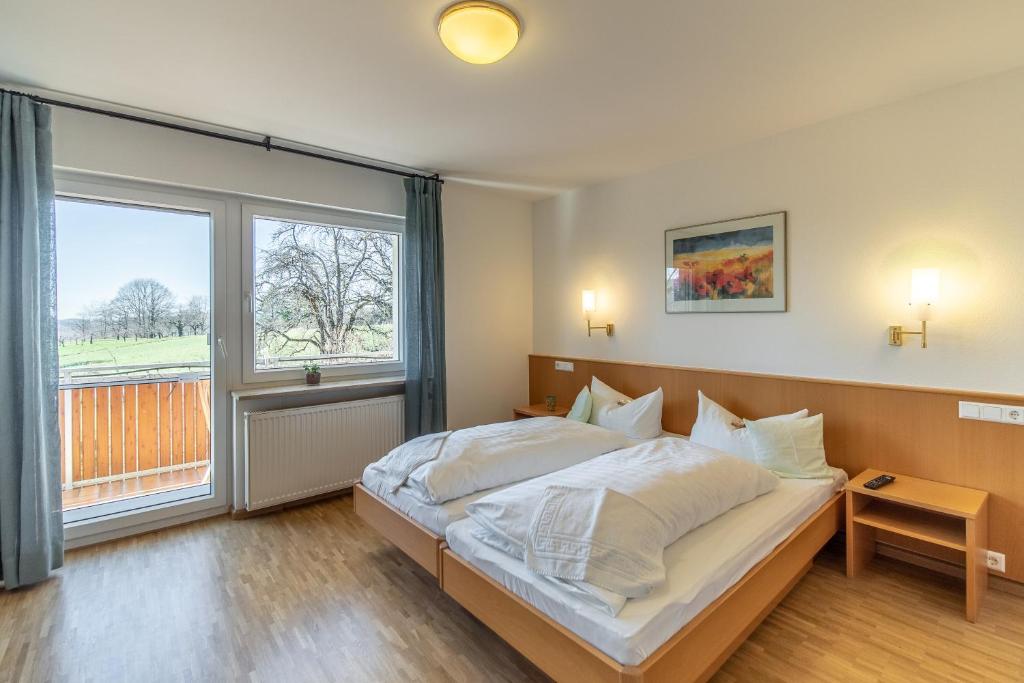 a bedroom with a bed and a large window at Haus am Blauenbach in Schliengen