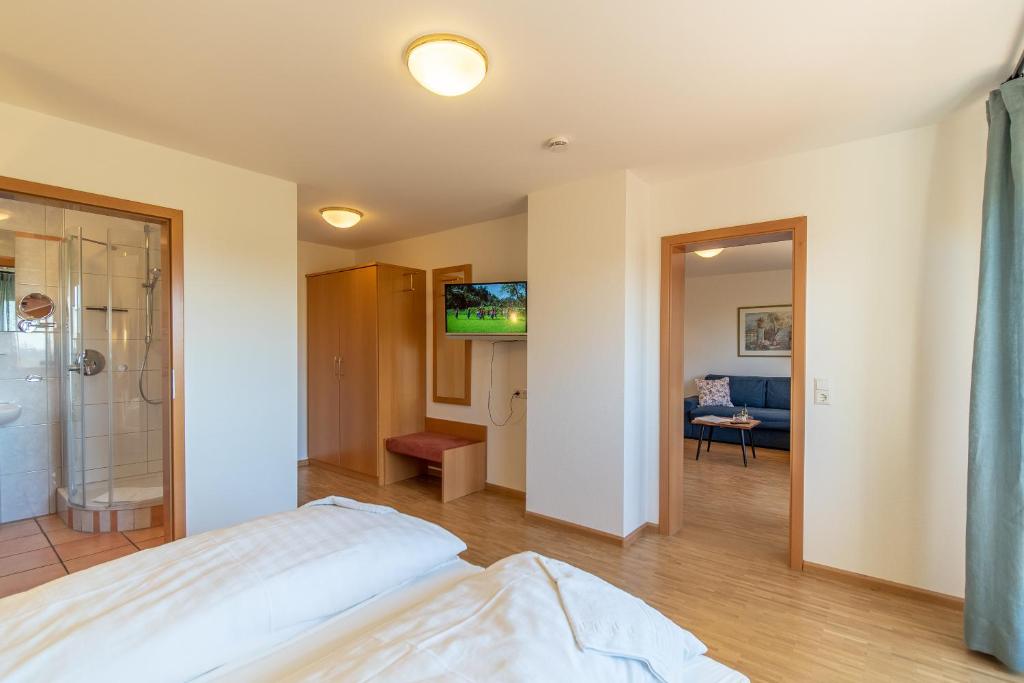 a bedroom with a bed and a walk in shower at Haus am Blauenbach in Schliengen