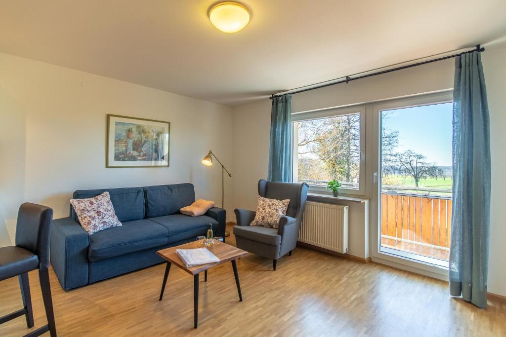 a living room with a blue couch and a window at Haus am Blauenbach in Schliengen