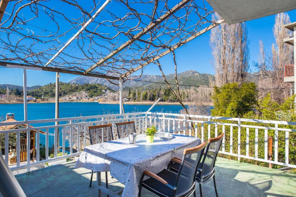 a table and chairs on a patio with a view of the water at Apartments Barbir in Ploče