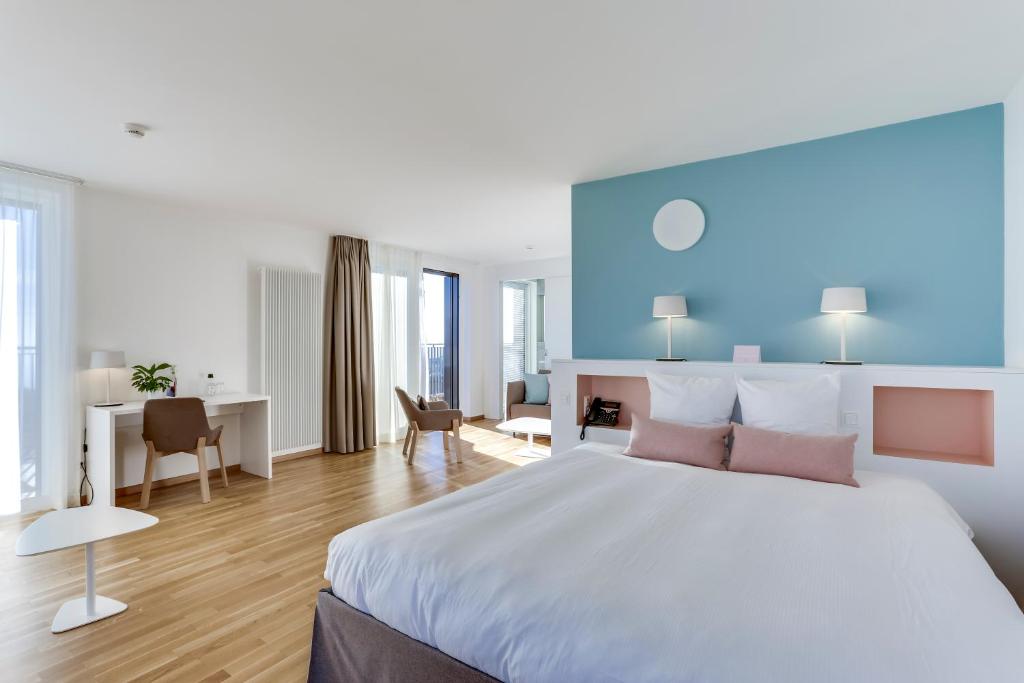 1 dormitorio con 1 cama grande y escritorio en Hôtel des Patients en Lausanne