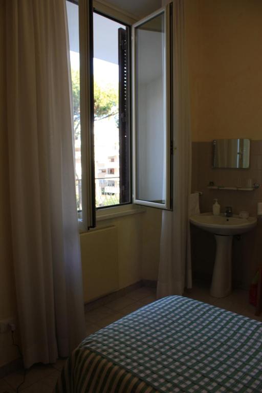 a bedroom with a bed and a sink and a window at Ostello Villa Monte Mario in Rome