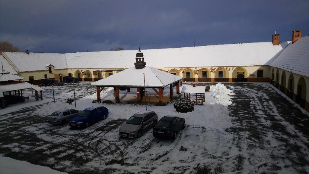 a group of cars parked in front of a building in the snow at Sudický Dvur in Boskovice