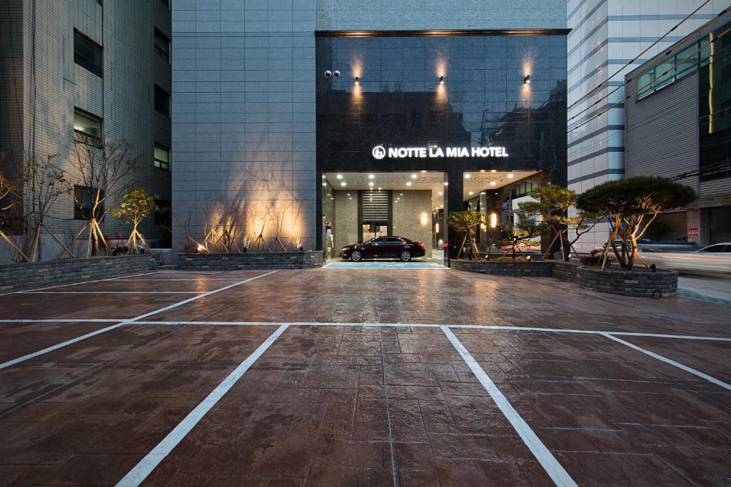 un parking vide devant un bâtiment dans l'établissement Notte La Mia Hotel, à Busan