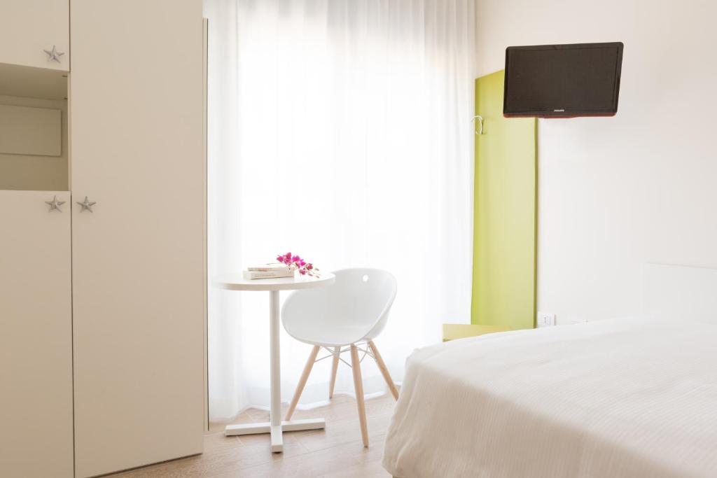 a bedroom with a bed and a table and a chair at Hotel Mediterraneo in Sottomarina