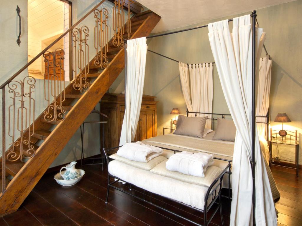 a bedroom with a bed and a staircase with white pillows at B&B Pronkenburg in Lissewege